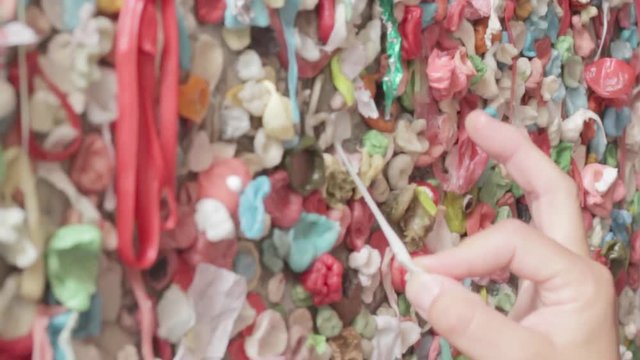 Sticking a piece of gum to the famous Seattle gum wall