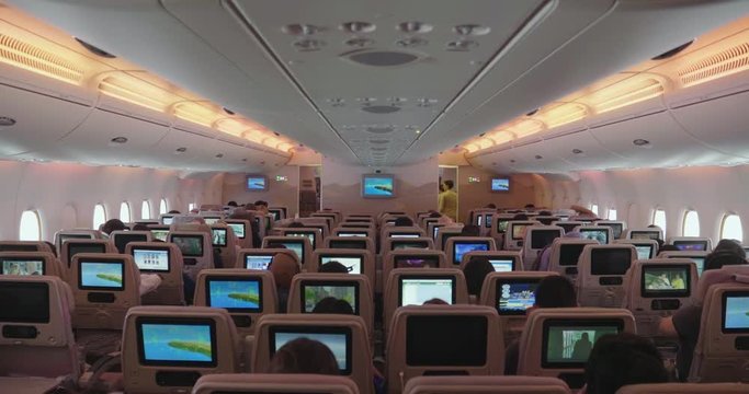 Airport of Bali/Indonesia - 22.06.2018 - Wide angle shot of an airplane interior ready to go, where each seat has a monitor to watch movies or surf the internet. Concept of: vacation, travel.