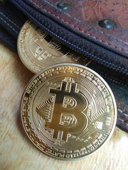 close up of two piece of bitcoin out from leather wallet