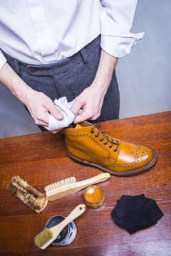 Footwear Ideas. Professional Male Shoes Cleaner Using Soft Cloth For Polishing Male Tan Brogue Derby Boots with Cream and Wax