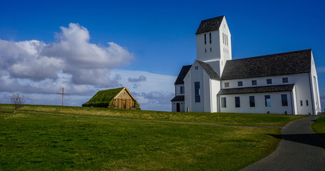 SKALFOLT, ICELAND - MAY 24, 2018: Beautiful church with a house with green roof and cross
