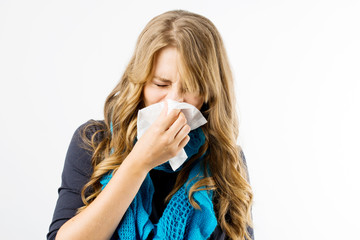 Young pregnant woman wearing blue scarf having flu and using handkerchief, white background .