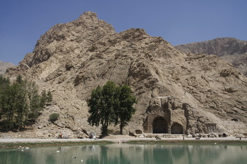 View of the Taq Bostan rock reliefs and a nearby pond