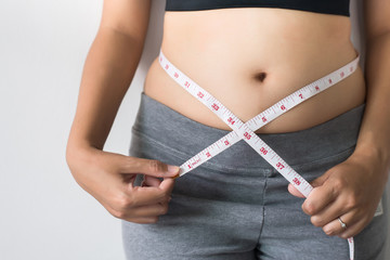 Woman measuring waist with  measuring tape,Excess belly fat and overweight fatty bellys of female