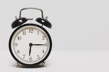 A black clock isolated on light color background.