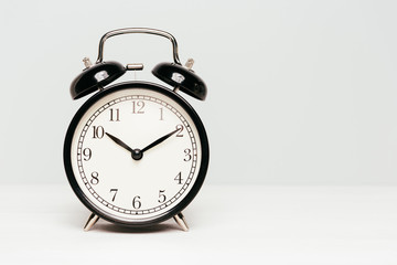A black clock isolated on light color background.