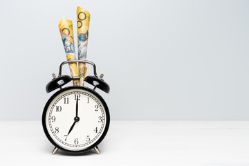 Clock and Australian money on light color background. Time is Money. Tax season concept.