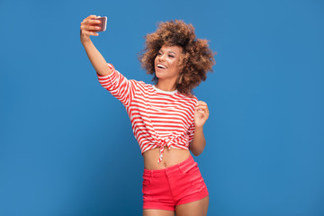 Beautiful african woman holding mobile phone and smiling.