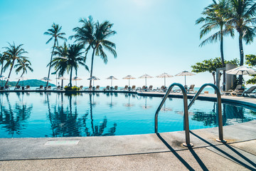 Beautiful tropical beach and sea with umbrella and chair around swimming pool