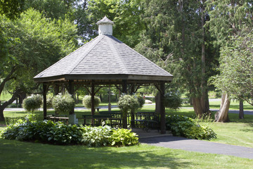 Wooden octagon shape gazebo with landcaping in a nature or park setting