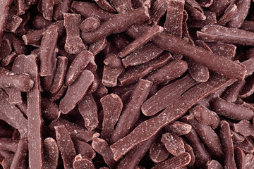 Candy dark chocolate background, copy space. Closeup of pile chocolate candies. Candy texture. Candy pattern. Sweets background. Abstract background. Top view, flat lay