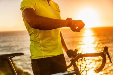 Smartwatch biking cyclist athlete using smart watch activity tracker gps during cycling training. Road bike sports man using his watch app for fitness tracking. Healthy lifestyle.