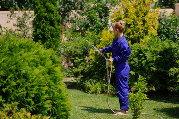 Gardener girl is watering the garden