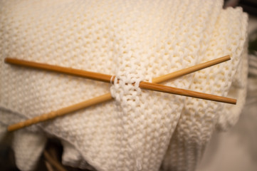 Soft homemade knitted wool with wooden needles closeup