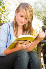 Young teen girl outside reading. © digitalskillet1