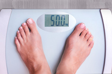 Woman on weighing. Perfect weight for a woman. Weight shows that a woman weighs 50 kg. Weight control_