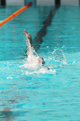 Swimmer swims backstroke or back crawl in a swimming pool for competition or race