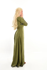 full length portrait of a blonde girl wearing green medieval gown, stand pose, isolated on white studio background. © faestock