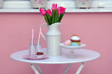 Table with pink tulips, bottles and cookies - 212297548