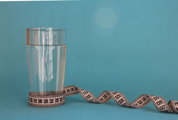 a glass of water with a centimeter tape spun a diet on the water