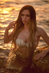Beautiful mermaid sitting on a rock