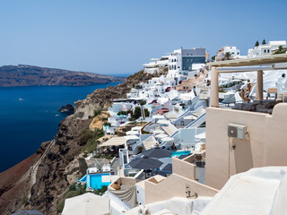 Oia village on Santorini island. Traditional and famous houses and churches with blue domes over the Caldera, Aegean sea. Greece, june 2018