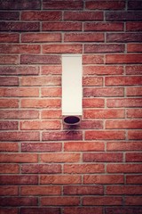 Outdoor wall light.lamp hanging on the weathered brick wall background with copy space.   