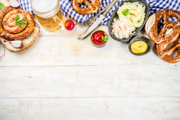 Oktoberfest food menu, bavarian sausages with pretzels, mashed potato, sauerkraut, beer bottle and mug, white wooden background copy space top view