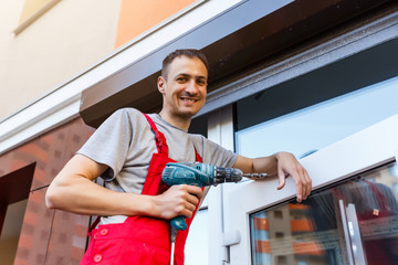 Man installing roller shutter on window