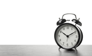 Alarm clock on table against white background. Time concept