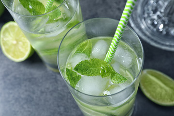 Glasses of natural lemonade with lime on table, closeup