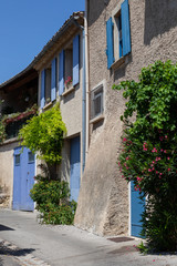 Fototapeta na wymiar Blue window shutters and doors in Ansouis, Provence, France