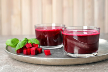 Glasses of fresh beet juice on metal tray