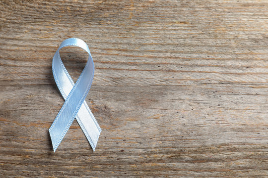 Grey ribbon on wooden background, top view. Cancer awareness