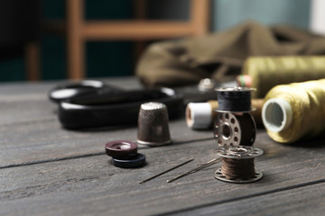 Bobbins with threads on table. Tailoring accessories