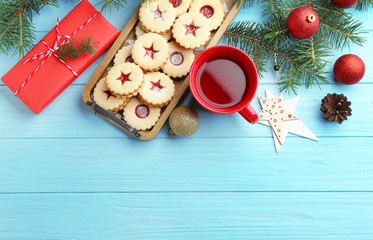 Christmas items and Linzer cookies with sweet jam on wooden background, top view