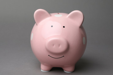 Cute pink piggy bank on gray background