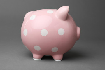 Cute pink piggy bank on gray background