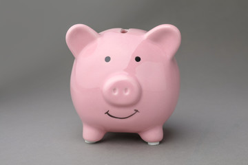 Cute pink piggy bank on gray background