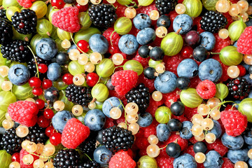 Fototapeta na wymiar Raspberries and mix of different berries as background
