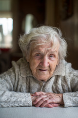 Gray-haired elderly woman portrait looking at the camera.