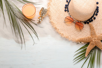 Flat lay composition with stylish hat and beach objects on wooden background