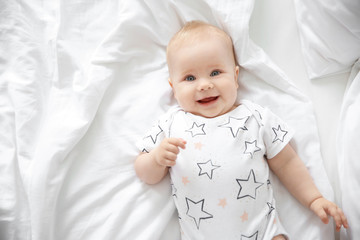 Cute little baby lying on bed, top view