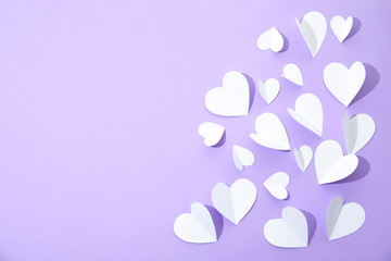 Small paper hearts on color background, top view