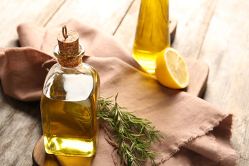 Composition with bottle of rosemary oil on wooden background
