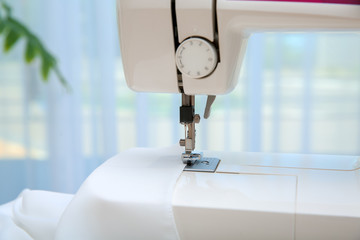 Sewing machine with textile near window, closeup