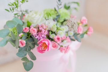 Pink vase with beautiful roses stands on the white table