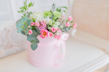 Pink vase with beautiful roses stands on the white table