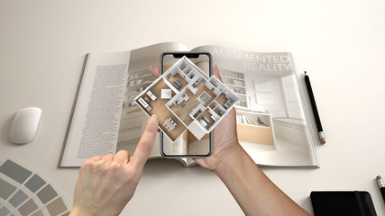Augmented reality concept. Hand holding smartphone with AR application used to simulate 3d pop-up interactive house maps to life