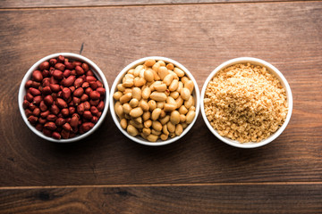 Crushed peanuts or mungfali powder with whole and roasted groundnut. Served in a bowl over moody background. Selective focus